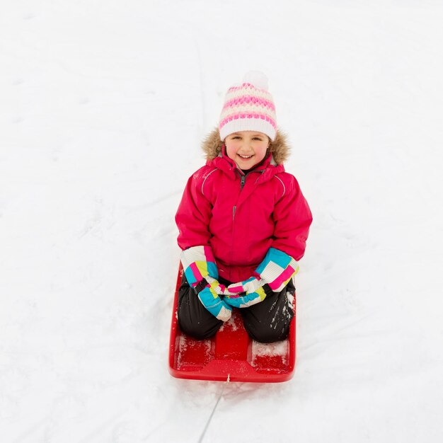 Фото Счастливая девушка едет на санях по снегу зимой