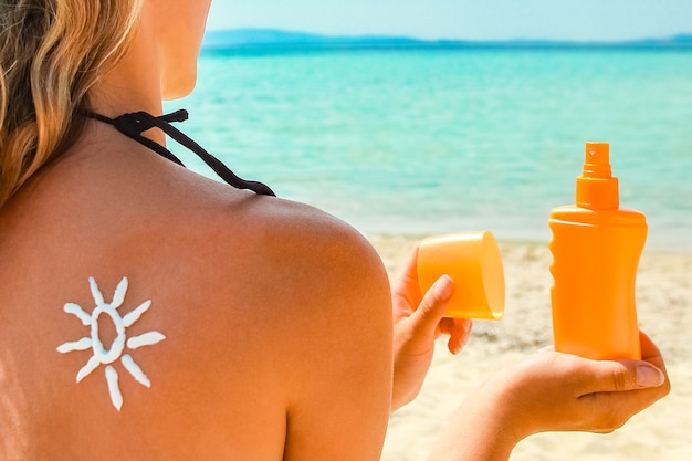 Happy girl on the sea with a picture of the sun on her back