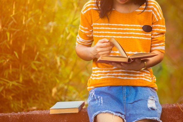 Happy girl sitting and reading a book