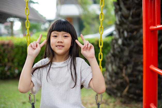 Happy girl sitting on a swing play ground