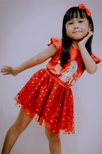 Happy girl standing against red background