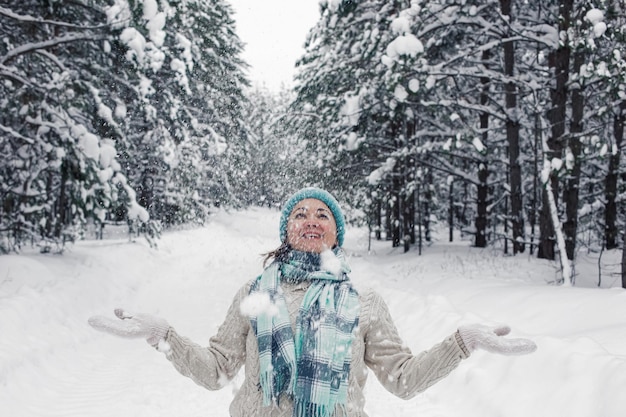 A happy girl stands in the winter forest