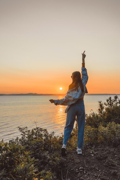 Happy girl in stylish clothes by the sea