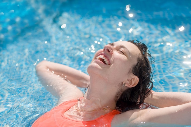 Happy girl swimming in the pool on a Sunny day closeup