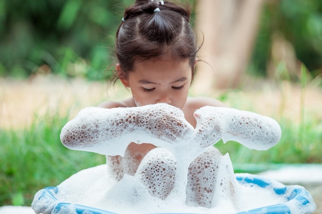 Happy girl taking bath in backyard