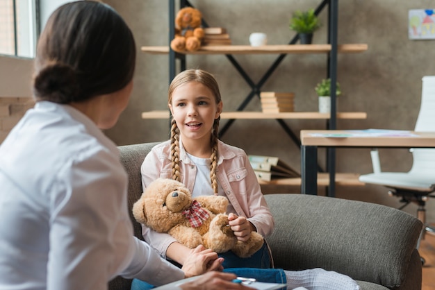 Happy girl talking to the female psychologist at home