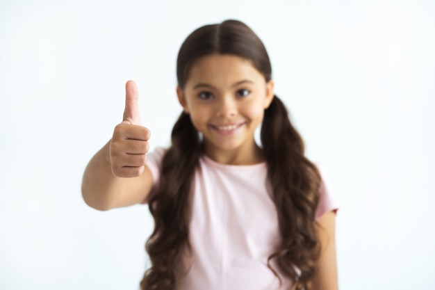 The happy girl thumbs up on the white background