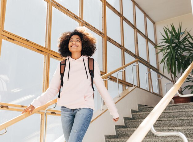 Happy girl walking in school building on stairs