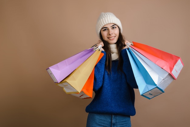 Happy girl in warm clothes with shopping bags, season of big discounts, copy space