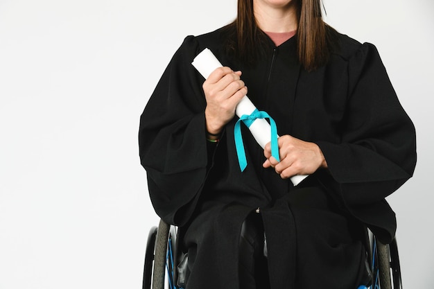 Happy girl in a wheelchair holding her diploma