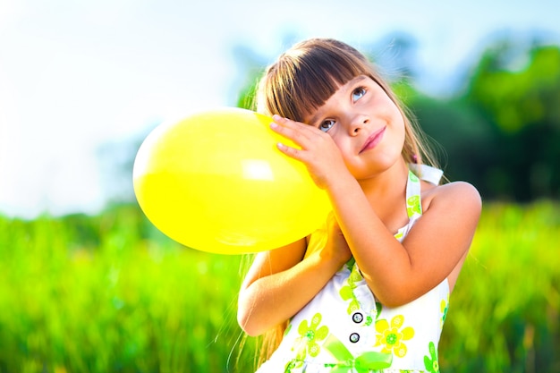 Happy girl with balloon on field