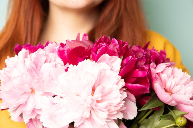 Happy girl with a bouquet of peonies 