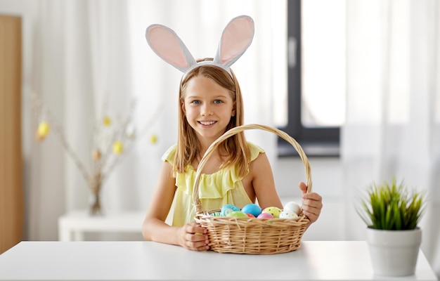 happy girl with colored easter eggs at home