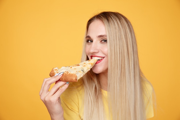 Happy girl with delicious cheese pizza isolated on yellow