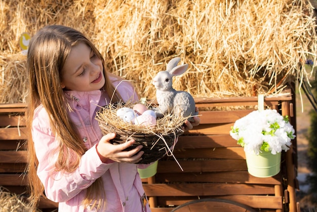 happy girl with easter bunny and eggs outdoor