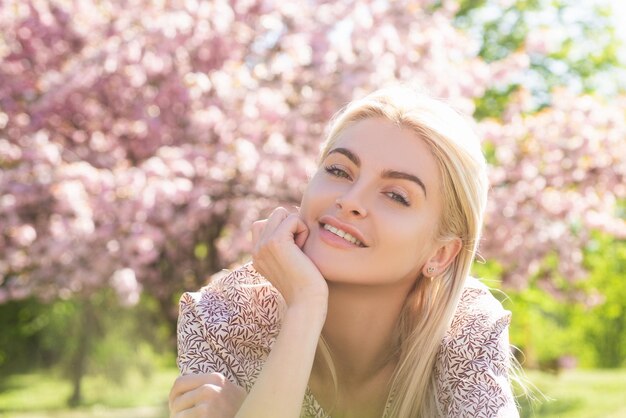 Happy girl with flowers in grass cute face of smiling young woman on spring dream woman