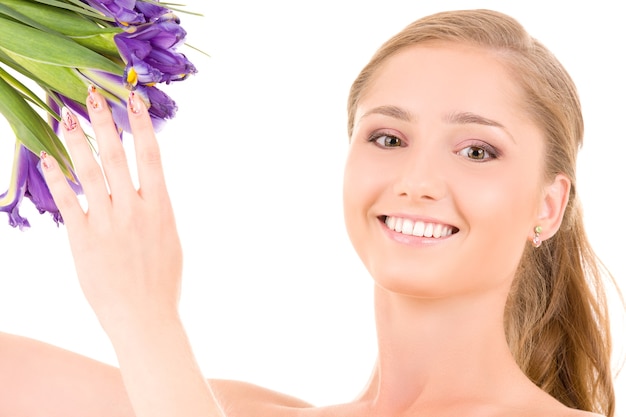 Happy girl with flowers over white wall