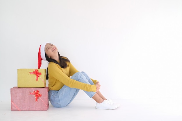 Photo happy girl with gift box and santa claus hat on whiye background