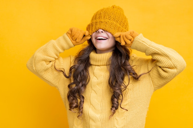 Happy girl with hat pulled over his eyes