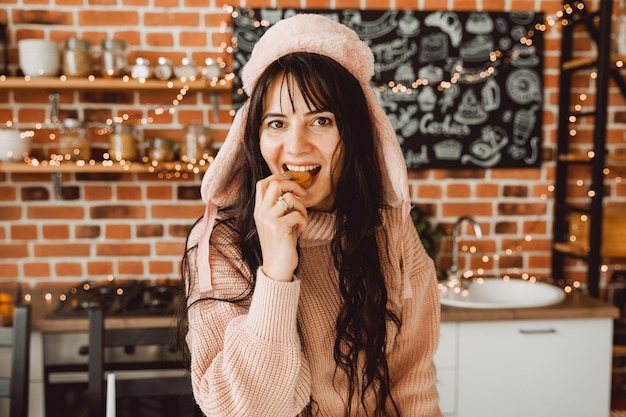 A happy girl with long dark hair bites an oatmeal diet cookie