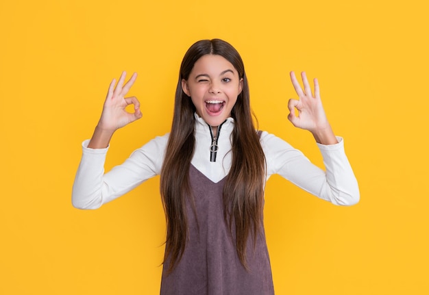 Happy girl with long hair on yellow background ok