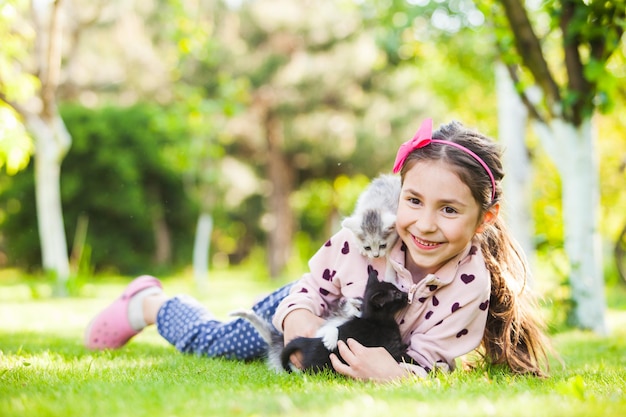 Happy girl with small kittens. cute girl playing with cat on natural background