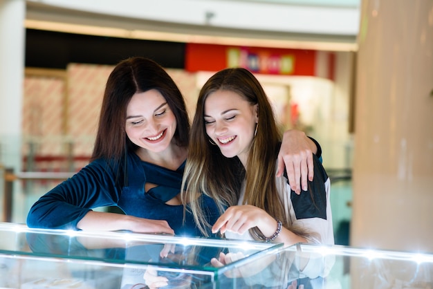 Le ragazze felici fanno shopping al centro commerciale.