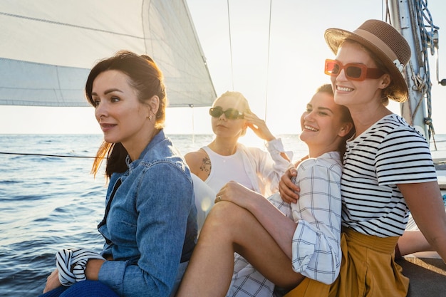 Happy girls friends on vacation relaxing on the sailboat during sailing in the sea