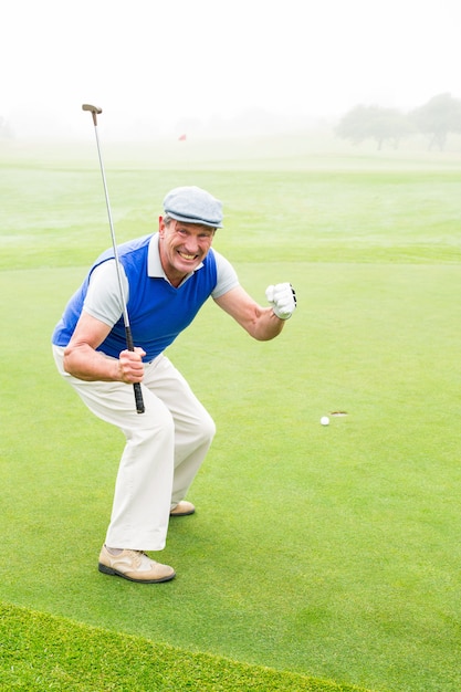 Happy golfer cheering on putting green