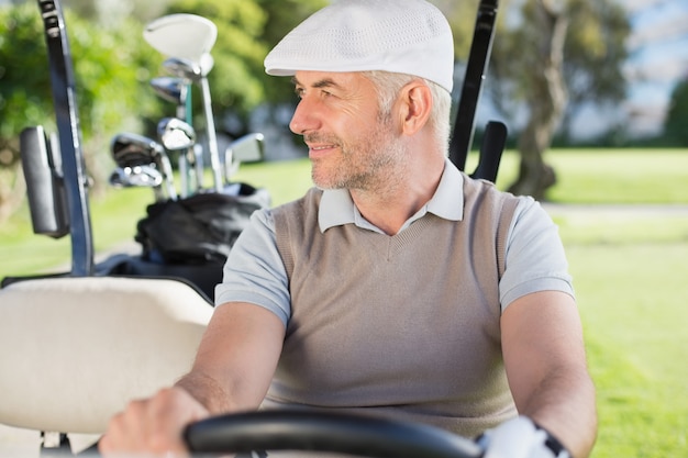 Photo happy golfer driving his golf buggy