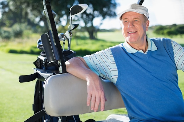Счастливый игрок в гольф за рулем своей багги