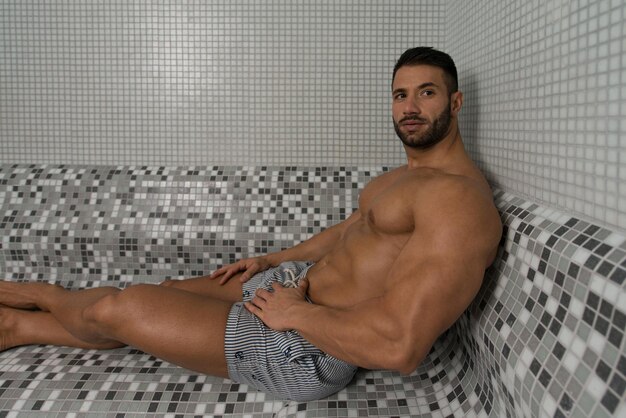 Happy Good Looking And Attractive Young Man With Muscular Body Relaxing In Hot Sauna