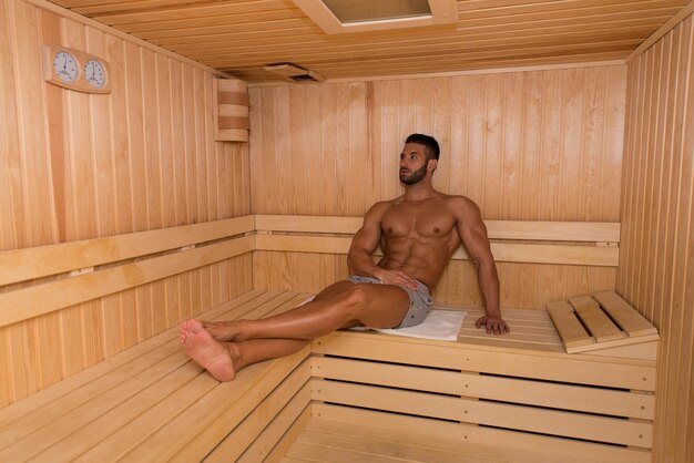 Happy Good Looking And Attractive Young Man With Muscular Body Relaxing In Hot Sauna