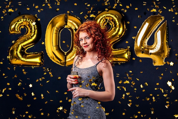 Фото Счастливая красивая девушка в стильном сексуальном партийном платье с золотом на новогодней вечеринке 2024 года