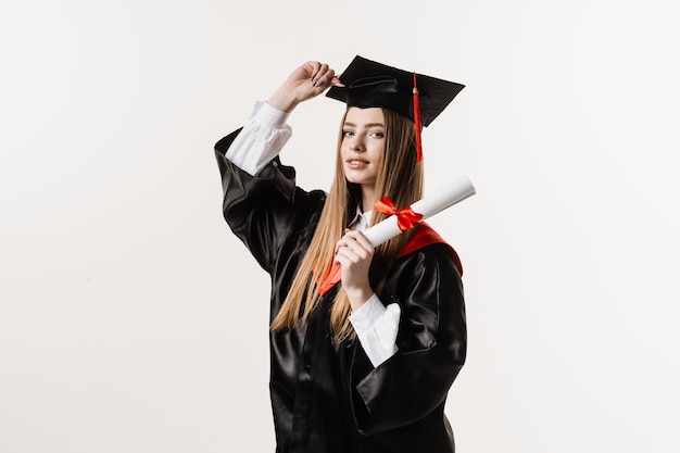 Happy graduate girl smiling and holding diploma with honors in her hands on white background Graduation Graduate girl graduated from university and got master degree