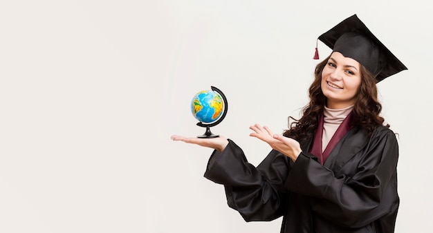 Happy graduate holding globe