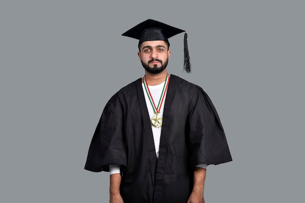 Happy graduate student isolated on grey background indian pakistani model