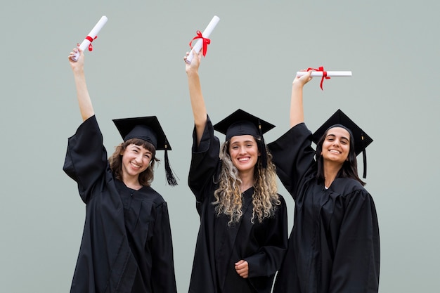 Счастливые выпускники празднуют с дипломами в воздухе