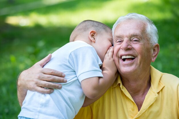 Photo happy grandfather and child have fun and play in park on beautiful  sunny day