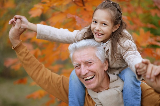 Happy grandfather and granddaughter in a park