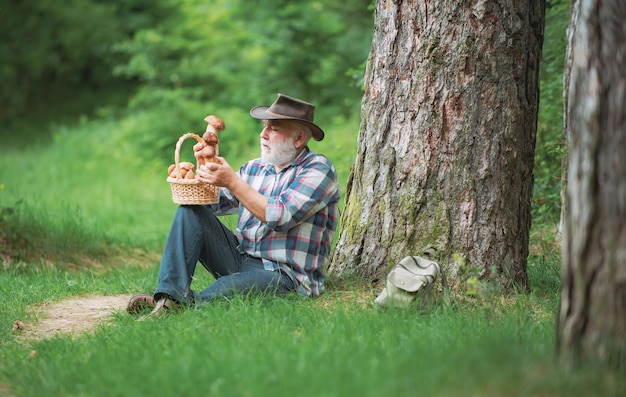 幸せな祖父の夏と趣味の老人が森のsprinでおじいちゃんの年金受給者のシニアハイキングを歩いています