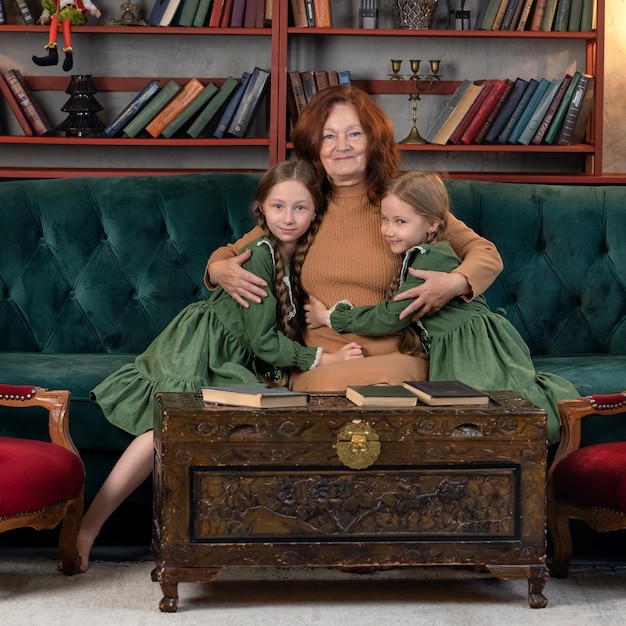 Happy grandma and grandchildren reading book together at home