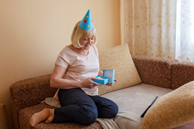 Happy grandmother celebrating birthday together with her family via internet in quarantine time