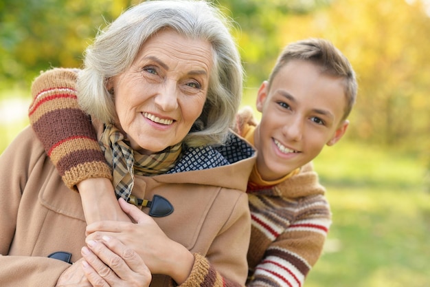 Happy grandmother and grandson posing in park