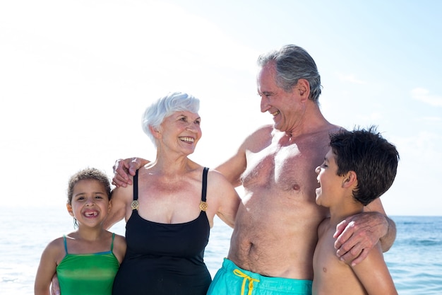 Happy granparents with grandchildren at beach