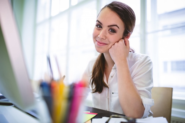 Happy graphic designer sitting at desk