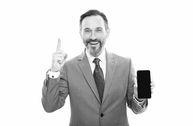 Happy grizzled entrepreneur presenting modern smartphone isolated on white copy space advise