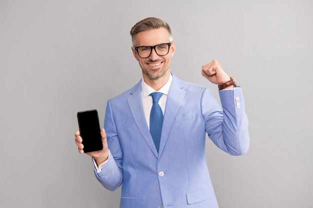 スーツとメガネの新しいアプリで携帯電話の画面を表示して幸せなグリズリ男