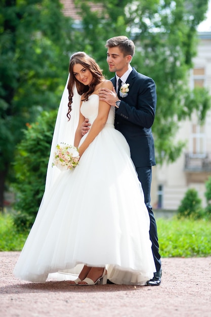 Happy groom and bride outdoor in the park