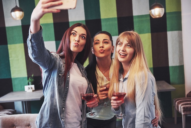 happy group of friends with red wine taking selfie